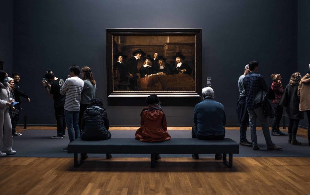 Groupe de visiteurs qui regardent une œuvre accroché au mur