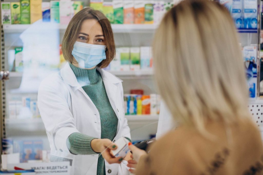 Pharmacien servant un client dans une pharmacie