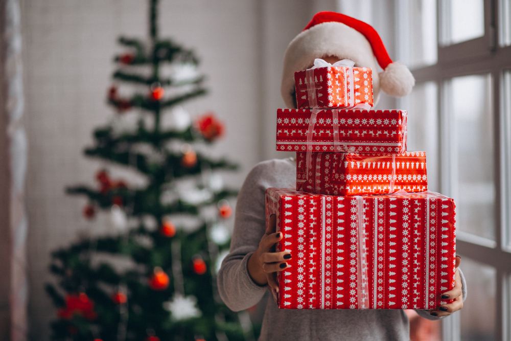 Femme tenant de gros cadeaux de Noël