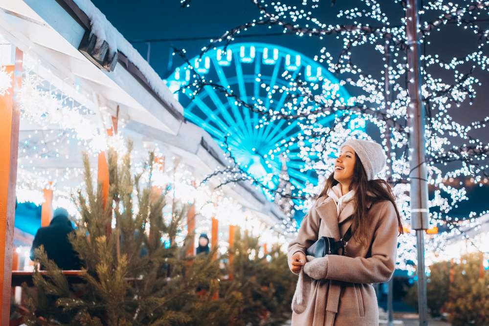 Fille posant sur fond d'arbres décorés